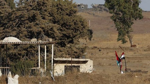 صورة تم التقاطها في 26 يوليو، 2018، بالقرب من كيبوتس عين زيفان في الجانب الإسرائيلي من هضبة الجولان، تظهر فيها الأعلام السورية (من اليمين) وأعلام حزب ’البعث’ السوري (من اليسار) وهي ترفرف عبر الحدود إثر استعادة قوات النظام لسيطرتها على المنطقة من المتمردين.  (AFP Photo/Jack Guez)