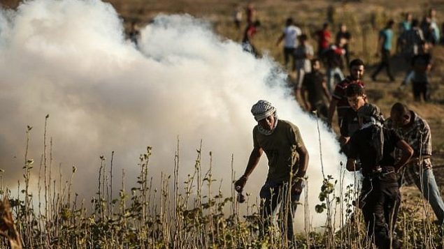 فلسطينيون يشاركون في مواجهات مع القوات الإسرائيلية على طول السياج الحدودي بين إسرائيل وقطاع غزة، شرق مدينة غزة في 27 يوليو / تموز 2018. (AFP Photo / Mahmud Hams)