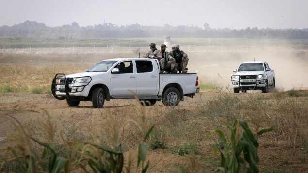 صورة توضيحية: اعضاء الجناح العسكري لحركة حماس يراقبون جرافات اسرائيلية تعمل على السياج الفاصل بين خان يونس، جنوب قطاع غزة، واسرائيل، 10 يونيو 2015 (Abed Rahim Khatib /Flash90) صورة توضيحية: اعضاء الجناح العسكري لحركة حماس يراقبون جرافات اسرائيلية تعمل على السياج الفاصل بين خان يونس، جنوب قطاع غزة، واسرائيل، 10 يونيو 2015 (Abed Rahim Khatib /Flash90)