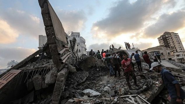 صورة تم التقاطها في 9 أغسطس، 2018 تظهر أشخاصا يتفقدون أنقاض مركز ثقافي في أعقاب غارة جوية إسرائيلية على مدينة غزة. (AFP PHOTO / MAHMUD HAMS)