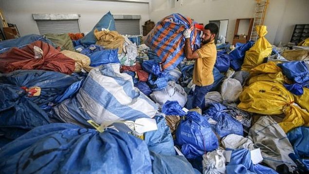 موظف في مكتب البريد الفلسطيني يدقق في أكياس بريد لم يتم تسليمها يعود تاريخها إلى عام 2010، بعد أن منعت إسرائيل إدخالها، في مكتب التبادل البريدي الدولي في مدينة أريحا في الضفة الغربية، 14 أغسطس، 2018.  (AFP / ABBAS MOMANI)