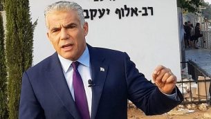 رئيس حزب ’يش عتيد’، عضو الكنيست يائير لابيد، يتحدث مع الصحافيين من أمام قاعدة الجيش الإسرائيلية الرئيسية للتجنيد، ’الباكوم’، في تل هشومير، 13 أغسطس، 2018.  (Courtesy)