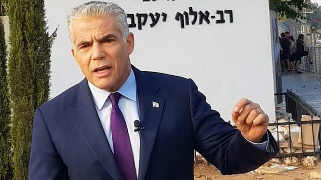 رئيس حزب ’يش عتيد’، عضو الكنيست يائير لابيد، يتحدث مع الصحافيين من أمام قاعدة الجيش الإسرائيلية الرئيسية للتجنيد، ’الباكوم’، في تل هشومير، 13 أغسطس، 2018.  (Courtesy)