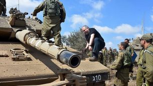 وزير الدفاع أفيغدور ليبرمان يتسلق دبابة في مرتفعات الجولان في 7 أغسطس عام 2018. (Ariel Hermoni/Defense Ministry)
