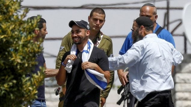 إيلور عزاريا، مركز، يزور مدينة الخليل في الضفة الغربية بعد اطلاق سراحه من السجن، حيث قضى عقوبة بتهمة القتل غير المتعمد عام 2016 لمعتدي فلسطيني في المدينة خلال خدمته العسكرية، 3 يوليو 2018 (Wisam Hashlamoun/Flash90)