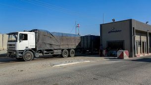 شاحنات فلسطينية في معبر كرم أبو سالم، نقطة العبور الرئيسية للبضائغ الداخلة إلى غزة من إسرائيل، في جنوب قطاع غزة في 9 يوليو، 2018. (Abed Rahim Khatib/Flash90)