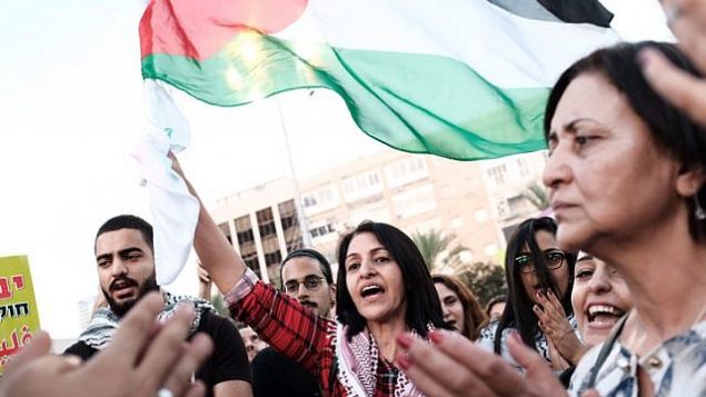 عرب اسرائيليون يرفعون اعلام فلسطينية خلال مظاهرة ضد قانون الدولة اليهودية في ساحة رابين في تل ابيب، 11 اغسطس 2018 (Tomer Neuberg/Flash90)