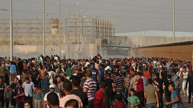 فلسطينيون يطلقون هتافات ويلوحون بأعلام خلال مواجهات عن معبر ’إيرز’ عند الحدود مع إسرائيل، 4 سبتمبر، 2018.  (AFP Photo/Mahmud Hams)