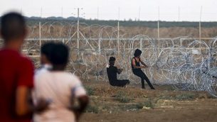 فلسطينيون يسحبون كابلا مربوطا بسياج شائك إثناء محاولتهم إسقاط قسم من السياج الأمني بين قطاع غزة وإسرائيل، خلال مواجهات على الحدود شرقي مدينة غزة، 7 سبتمبر، 2018.(AFP/Said Khatib)