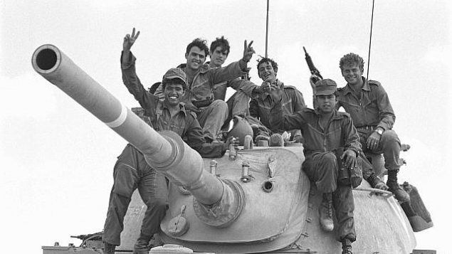 جنود يقفون على قمة دبابة أثناء اندلاع حرب أكتوبر في 6 أكتوبر 1973. (Avi Simhoni/Bamahane/Defense Ministry Archives)