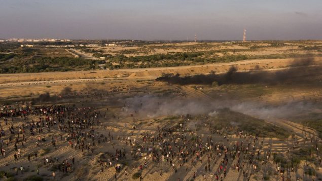صورة جوية لمتظاهرين يفرون من الغاز المسيل للدموع الذي اطلقه جنود اسرائيليون خلال مظاهرة في شاطئ في بيت لاهيا، بالقرب من الحدود مع اسرائيل، 17 سبتمبر 2018 (AP/Felipe Dana) صورة جوية لمتظاهرين يفرون من الغاز المسيل للدموع الذي اطلقه جنود اسرائيليون خلال مظاهرة في شاطئ في بيت لاهيا، بالقرب من الحدود مع اسرائيل، 17 سبتمبر 2018 (AP/Felipe Dana)