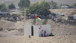 طفلات فلسطينيات يقفن إلى جانب حاوية شحن تم وضعها حديثا في قرية الخان الأحمر البدوية، 11 سبتمبر، 2018.   (AP Photo/Majdi Mohammed)