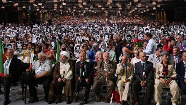 اشخاص يحملون صورا لأقاربهم الذين قُتلوا بأيدي النظام الإيراني خلال حدث "إيران حرة 2018 - البديل" في 30 يونيو، 2018، في فيلبانت، شمال فرنسا.  (AFP Photo/Zakaria Abdelkafi)