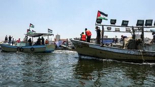 ناشطون يرافقون قارب على متنه فلسطينيين اصيبوا خلال الاشتباكات عند السياج الامني حول غزة، اثناء محاولته كسر الحصار البحري الذي تفرضه اسرائيل، 10 يوليو 2018 (Mahmud Hams/AFP)