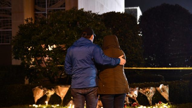 اشخاص يقفون امام شموع مضاءة خارج كنيس ’شجرة الحياة’ بعد هجوم اطلاق نار راح ضحيته 11 شخصا في بتسبورغ، 27 اكتوبر 2018 (Brendan Smialowski / AFP)