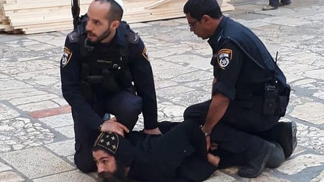 ضباط شرطة إسرائيل يكبحون رجل دين قبطيا خلال احتجاج على أعمال صيانة للسلامة في كنيسة القيامة في مدينة القدس القديمة، 24 أكتوبر / تشرين الأول 2018.  (Patriarchate of the Orthodox Copts in Jerusalem/Facebook)