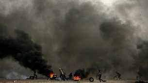 فلسطينيون يشعلون إطارات في احتجاجات خلال "مسيرة العودة" على حدود غزة-إسرائيل في رفح، قطاع غزة في 12 أكتوبر، 2018. (Abed Rahim Khatib/Flash90) فلسطينيون يشعلون إطارات في احتجاجات خلال "مسيرة العودة" على حدود غزة-إسرائيل في رفح، قطاع غزة في 12 أكتوبر، 2018. (Abed Rahim Khatib/Flash90)