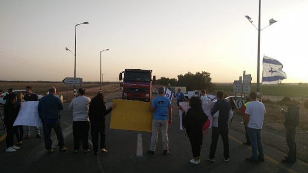 سكان من الجنوب ونشطاء من منظمة ’إم ترتسو’ اليمينية يمعنون شاحنات من دخول غزة عبر معبر كيرم شالوم، 29 أكتوبر، 2019. (Im Tirtzu)
