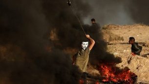 فلسطييني يستخدم المقلاع لإلقاء حجارة خلال مظاهرة على الشاطئ بالقرب من الحدود البحرية مع إسرائيل، في بيت لاخيا في جنوب قطاع غزة، 29 أكتوبر، 2018. (MAHMUD HAMS / AFP)