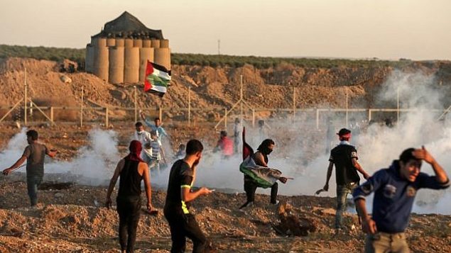 رد الفلسطينيين على الغاز المسيل للدموع الذي أطلقته القوات الإسرائيلية خلال اشتباكات شرق مدينة غزة بالقرب من الحدود بين قطاع غزة وإسرائيل في 2 نوفمبر 2018. (Mahmud Hams/AFP)