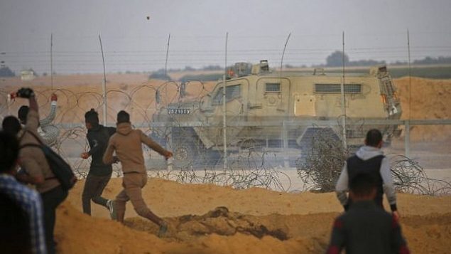 صورة توضيحية: الفلسطينيون يلقون بالحجارة على سيارة تابعة للجيش الإسرائيلي خلال اشتباكات بين إسرائيل وخان يونس في جنوب قطاع غزة في 9 نوفمبر / تشرين الثاني 2018. (Said Khatib/AFP)