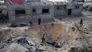 فلسطينيون يفحصون حفرة ناتجة عن غارة اسرائيلية خلال القتال مع حركات فلسطينية، في رفح، جنوب قطاع غزة، 14 نوفمبر 2018 (Said Khatib/AFP)