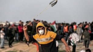 متظاهر فلسطيني يقذف حجراً باتجاه القوات الإسرائيلية خلال اشتباكات على طول الشريط الحدودي مع قطاع غزة شرق مدينة غزة في 30 نوفمبر / تشرين الثاني 2018. (Mahmud Hams/AFP)