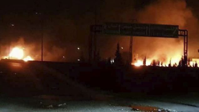 صورة توضيحية: صورة اصدرتها وكالة سانا السورية الرسمية للانباء في 9 مايو 2018، تظهر النيران تتصاعد في اهقال هجوم في منطقة تحوي العديد من القواعد العسكرية السورية، في الكسوة، جنوب دمشق (SANA via AP)