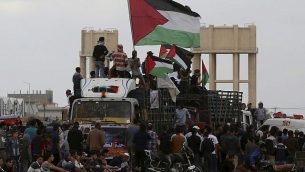 متظاهرون فلسطينيون يلوحون بالإعلام الفلسطينية أثناء ركوب شاحنة مليئة بالإطارات بالقرب من السياج الحدودي بين قطاع غزة وإسرائيل خلال مظاهرة في مدينة غزة، الجمعة، 26 أكتوبر، 2018.  (AP/Adel Hana)
