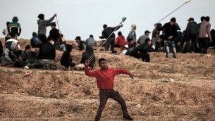متظاهر فلسطيني يستخدم المقلاع لإلقاء حجارة على القوات الإسرائيلية خلال تظاهرة في 16 نوفمبر، 2018، على الأطراف الشرقية لمدينة غزة، بالقرب من الحدود مع إسرائيل.  (Mahmud Hams/AFP)