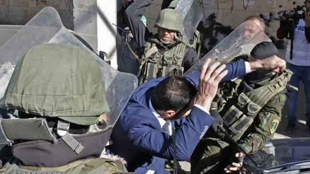 قامت قوات الأمن الفلسطينية تضرب أحد أنصار حماس أثناء محاولتها تفريق مظاهرة بمناسبة الذكرى الحادية والثلاثين لتأسيس الجماعة في الخليل في 14 ديسمبر 2018. (Hazem Bader/AFP)