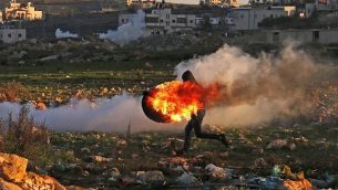 فلسطيني وسط الدخان خلال الاشتباكات مع القوات الإسرائيلية في رام الله في 14 ديسمبر، 2018. (Abbas Momani/AFP)