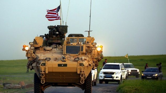 القوات الأمريكية، بمرافقة مقاتلين من وحدات حماية الشعب الكردية (YPG)، تقود مركباتها المدرعة بالقرب من قرية درابسية في شمال سوريا، على الحدود مع تركيا، 28 أبريل 2017. (Delil Souleiman / AFP)