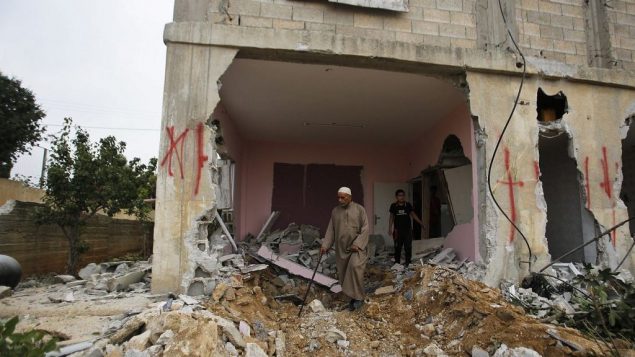 فلسطيني يفحص منزل هدمته السلطات الإسرائيلية في قرية كوبر، 16 اغسطس 2017 (AP Photo/Nasser Shiyoukhi)
