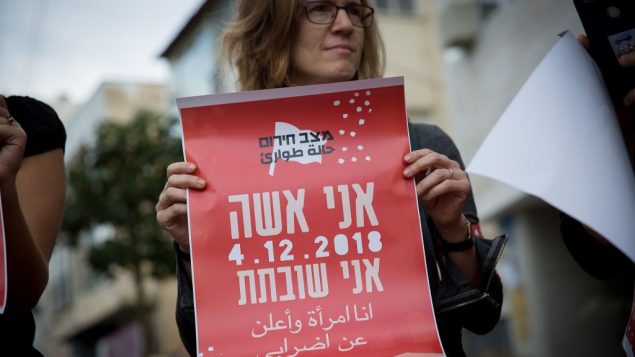امرأة تحمل لافتة تعلن عن اضاربها، خلال مظاهرة في تل ابيب، 2 ديسمبر 2018 (Miriam Alster/Flash90) امرأة تحمل لافتة تعلن عن اضاربها، خلال مظاهرة في تل ابيب، 2 ديسمبر 2018 (Miriam Alster/Flash90)