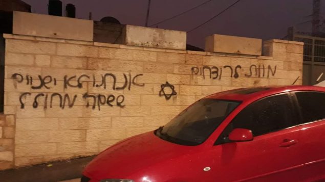 سيارة في حي بيت حانينا في القدس الشرقية تم تمزيق اطاراتها امام جدار رُسم عليه نجمة داود وعبارات ’الموت للقتلى’ و’لن ننام بينما يتم تدنيس اسم الله’ في 20 ديسمبر 2018 (Courtesy)