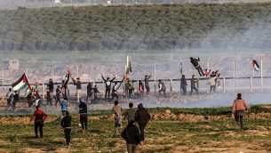 متظاهرون فلسطينيون يحاولون تسلق السياج الحدودي مع إسرائيل خلال مواجهات اندلعت بعد مظاهرات على طول الحدود في شرق مدينة غزة، 4 يناير، 2019. (Said Khatib/AFP)