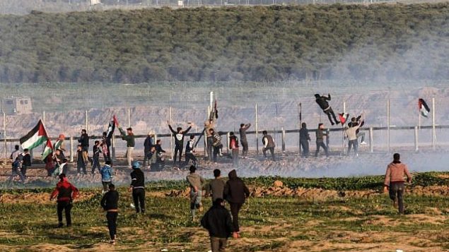 متظاهرون فلسطينيون يحاولون تسلق السياج الحدودي مع إسرائيل خلال مواجهات اندلعت بعد مظاهرات على طول الحدود في شرق مدينة غزة، 4 يناير، 2019. (Said Khatib/AFP)