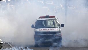 سيارة اسعاف فلسطينية تخرج مع غمامة غاز مسيل للدموع خلال اشتباكات بين فلسطينيين وقوات اسرائيلية في مدينة بيت لحم بالضفة الغربية، 15 مايو 2018 (AP Photo/Majdi Mohammed)