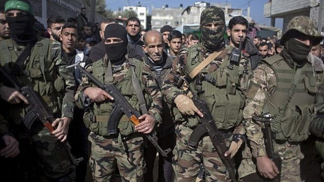 مسلحون ملثمون تابعون لحركة ’حماس’ خلال جنازة محمود النباهين (24 عاما) في مخيم البريج، في وسط قطاع غزة، 23 يناير، 2019. (AP Photo/ Khalil Hamra))