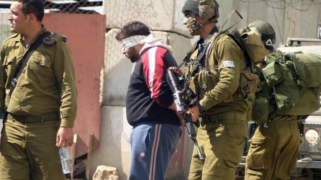 صورة توضيحية لجنود إسرائيليين يقوم بتعصيب أعين معتقلين فلسطينيين.  (Najeh Hashlamoun/Flash90)