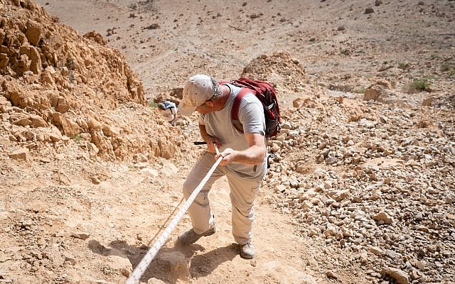 الباحث أورين غوتفيلد ينحدر من الكهف 52، في موقع قمران الأثري، 22 يناير، 2019. (Luke Tress / Times of Israel)