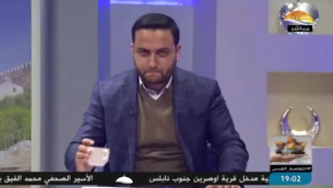 مذيع أخبار على تلفزيون ’الأقصى’ التابع لحركة ’حماس’ يضع كوبا من الشاي على الطاولة أمامه في ما يقول جهاز الأمن العام (الشاباك) إنه رمز سري لعنصر في الضفة الغربية. (Screen capture: Al-Aqsa TV/Shin Bet)