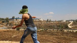 توضيحية: فلسطيني من قرية النبي صالح في الضفة الغربية يلقي بحجر على الجنود الإسرائيليين. (Eric Cortellessa/Times of Israel)