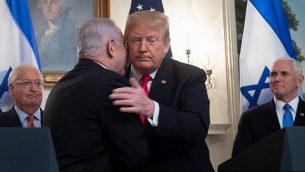 عناق بين الرئيس الأمريكي دونالد ترامب (من اليمين) ورئيس الوزراء بنيامين نتنياهو قبيل التوقيع على وثيقة تعترف بالسيادة الإسرائيلية على الجولان في الغرفة الدبلوماسية في البيت الأبيض، 25 مارس، 2019. ديفيد فريدمان يظهر في يسار الصورة.  (SAUL LOEB/AFP)