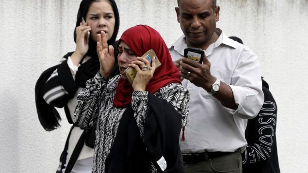 أشخاص ينتظرون خارج مسجد في مدينة كرايست تشيرتش النيوزيلندية، الجمعة، 15 مارس، 2019. (AP Photo/Mark Baker)