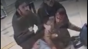 جندي اسرائيلي يمسكه حارسين امنيين في محطة قطار في بئر السبع، بعد ان ضربه الحراس لرفضه المفترض اظهار بطاقة هويته، 3 مارس 2019 (Screen capture: Facebook)