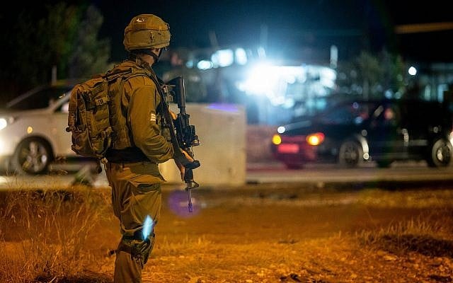 توضيحية: جنود إسرائيليون يقفون بالقرب من موقع ما يُشتبه بأنه هجوم دهس عند مدخل قرية حوسان، في الضفة الغربية، 23 يونيو، 2018. (Flash90)