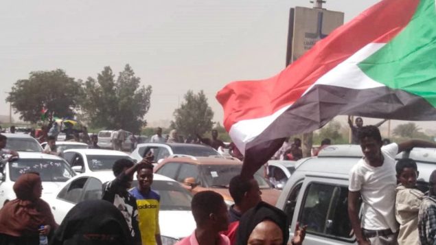 متظاهرون سودانيون يسيرون باتجاه مقر الجيش خلال تظاهرة في العاصمة الخرطوم، 11 أبريل، 2019.  (Photo by - / AFP)
