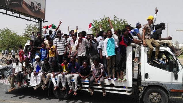 رجال سودانيون يحتفلون خلال مظاهرات في الخرطوم، 11 ابريل 2019 (AFP)